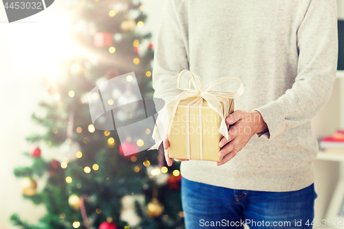 Image of close up of man with christmas gift at home