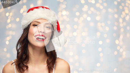 Image of woman with red lipstick in santa hat on christmas