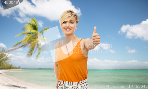 Image of happy smiling young woman showing thumbs up