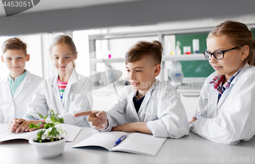 Image of kids or students with plant at biology class