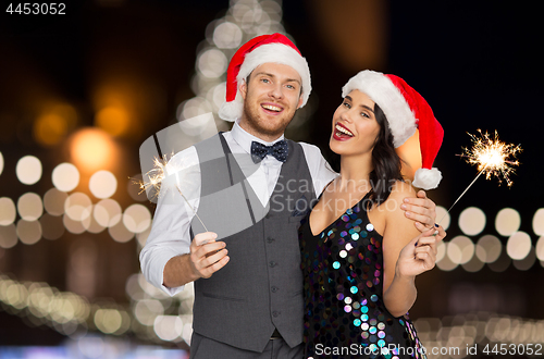 Image of happy couple with sparklers at christmas party
