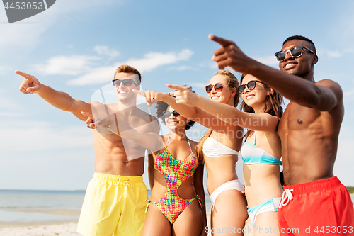 Image of happy friends hugging on summer beach
