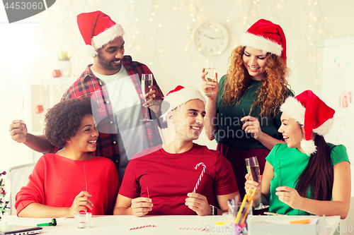 Image of happy team celebrating christmas at office party