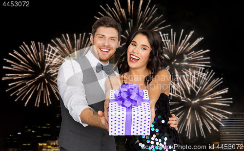 Image of happy couple with gift box at birthday party