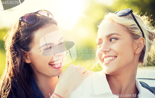 Image of happy women or teenage girls laughing outdoors