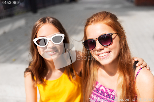 Image of smiling teenage girls in sunglasses outdoors