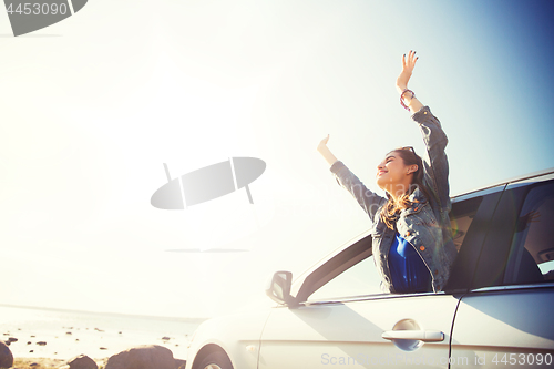 Image of happy teenage girl or young woman in car