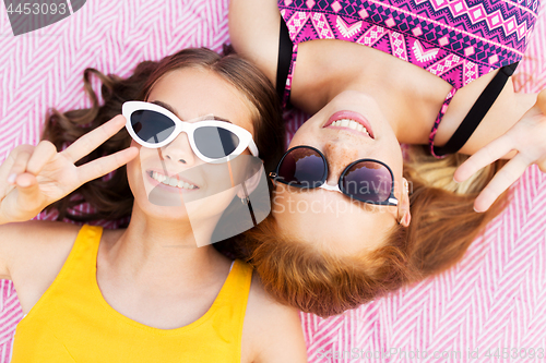 Image of teenage girls in sunglasses showing peace sign