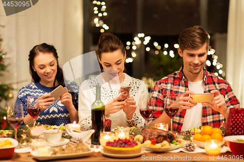 Image of happy friends having christmas dinner at home