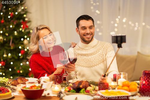 Image of happy couple taking selfie at christmas dinner