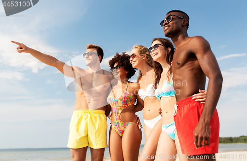 Image of happy friends hugging on summer beach