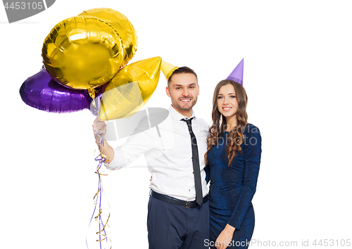 Image of happy couple with party caps and balloons