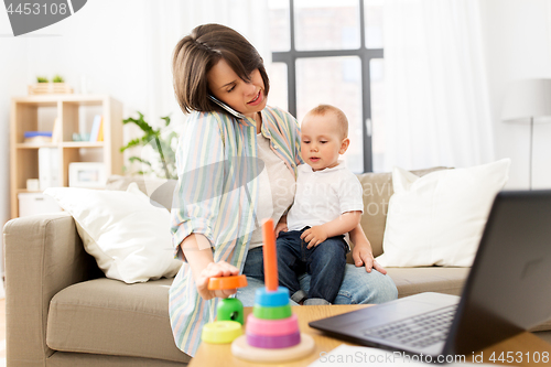 Image of working mother with baby calling on smartphone