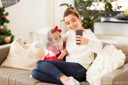Image of family taking selfie by smartphone at home