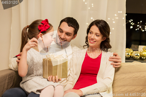 Image of happy family with christmas present at home