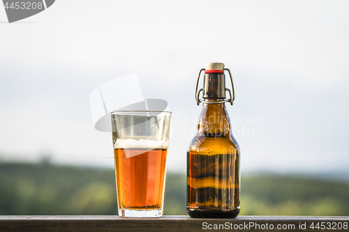 Image of Glass of beer next to a bottle