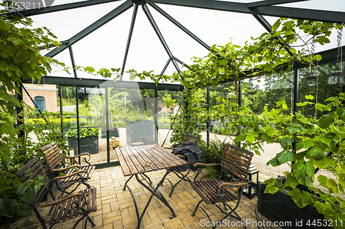 Image of Terrace in a glass house with wooden garden furniture