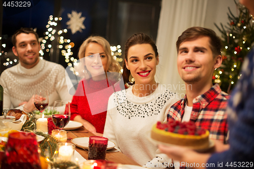 Image of happy friends having christmas dinner at home