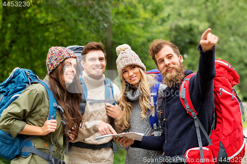 Image of friends or travelers hiking with backpacks and map