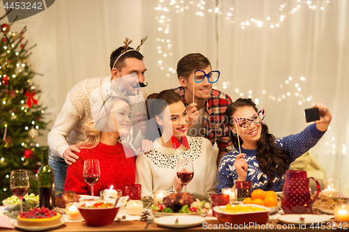 Image of friends taking selfie at christmas dinner