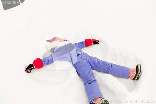 Image of happy little girl making snow angels in winter