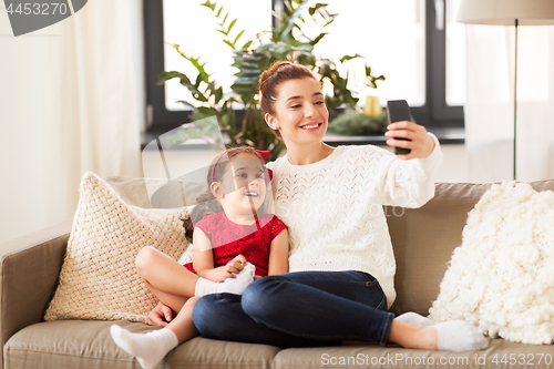 Image of family taking selfie by smartphone at home