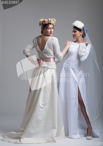 Image of Portrait of two beautiful young bride in wedding dresses