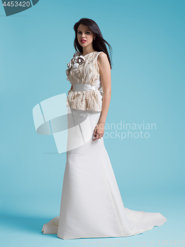 Image of beautiful woman wearing wedding dress against cyan background