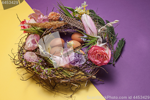 Image of Easter card. Painted Easter eggs in nest on yellow background