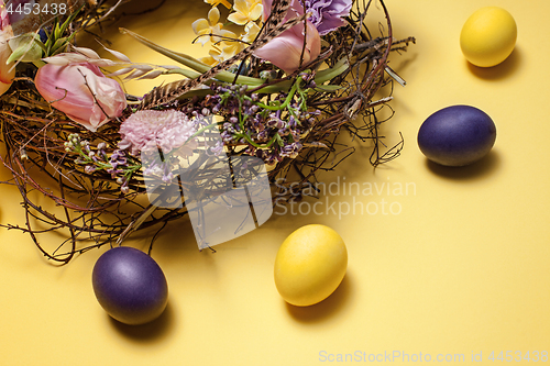 Image of Easter card. Painted Easter eggs in nest on yellow background