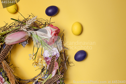 Image of Easter card. Painted Easter eggs in nest on yellow background