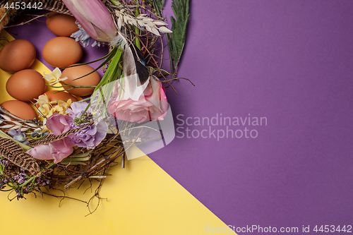 Image of Easter card. Painted Easter eggs in nest on yellow background