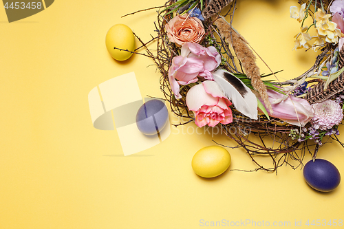 Image of Easter card. Painted Easter eggs in nest on yellow background