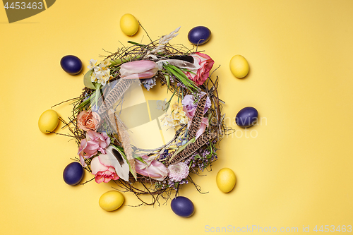 Image of Easter card. Painted Easter eggs in nest on yellow background