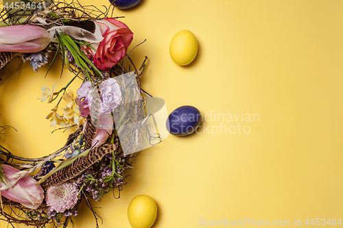 Image of Easter card. Painted Easter eggs in nest on yellow background