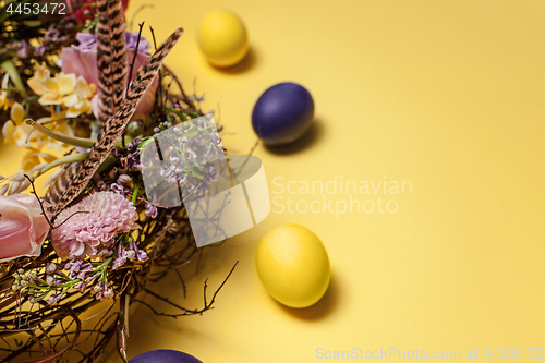 Image of Easter card. Painted Easter eggs in nest on yellow background