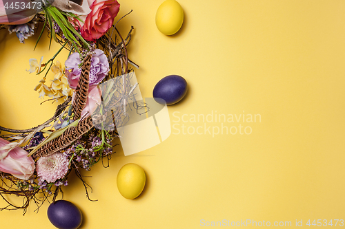 Image of Easter card. Painted Easter eggs in nest on yellow background