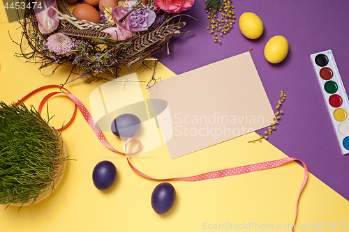 Image of Easter card. Painted Easter eggs in nest on yellow background