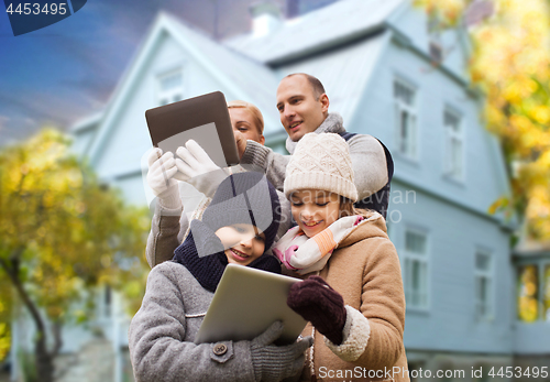 Image of family with tablet pc over living house in autumn
