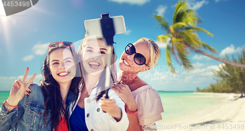 Image of group of smiling women taking selfie on beach