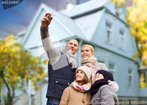 Image of family takes autumn selfie by camera over house