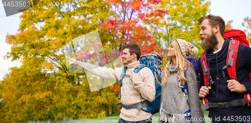 Image of group of friends with backpacks hiking in autumn