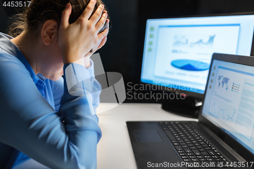 Image of businesswoman with computer at night office