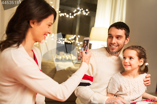 Image of happy family taking picture at christmas dinner