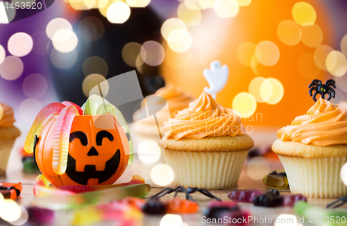 Image of halloween party decorated cupcakes on wooden table