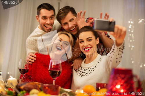 Image of friends taking selfie at christmas dinner