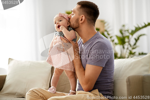 Image of father kissing little baby daughter