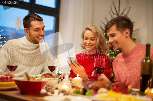 Image of friends with cellphone celebrate christmas at home