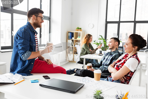 Image of creative team drinking coffee at office