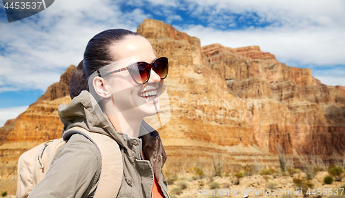 Image of smiling woman with backpack over grand canyon